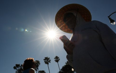 Una persona lleva un sombrero para protegerse del sol matutino mientras camina por The Strand en Redondo Beach, California, el 20 de marzo de 2026, durante una ola de calor.