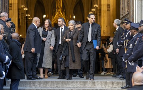 Alejandro Miguel Colón junto Julia Colón Craig, hijo y esposa del fallecido cantante Willie Colón, reaccionan al finalizar una misa pública..
