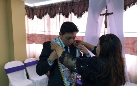 Los padres inculcan la fe en los jóvenes que participan en el arrastre de las banderas en Viernes Santo.