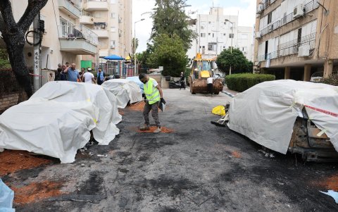 Trabajadores municipales limpian los destrozos en el lugar donde impactó un misil iraní en Petah Tikva, Israel, el 31 de marzo de 2026.