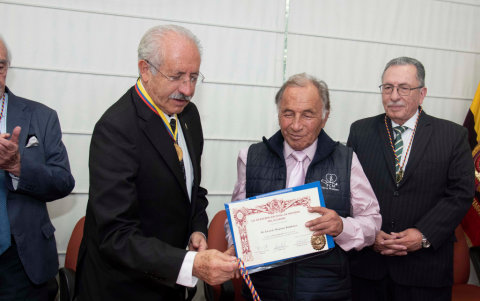 César Alarcón, director de la Academia Nacional de Historia del Ecuador, entrega el diploma al doctor Eduardo Mosquera.