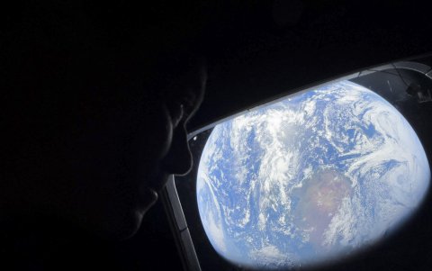 El comandante Reid Wiseman observa la Tierra mientras continúan adentrándose en el espacio hacia la Luna.