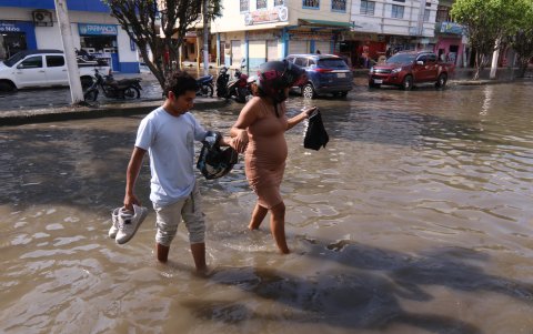 Complicaciones. Una mujer embarazada camina entre el agua para ser atendida.