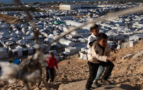 Niños palestinos desplazados juegan junto a sus tiendas de campaña dentro de un campamento de refugio temporal instalado en el sur de la Franja de Gaza.