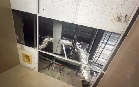 Baños. Sobre uno de los sanitarios se pueden observar los ductos de aire acondicionado.