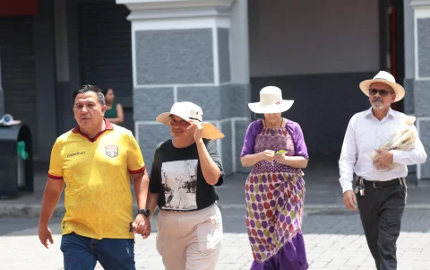 Sombrillas, gorras y botellas de agua se convierten en aliados frente al sol intenso en las calles.