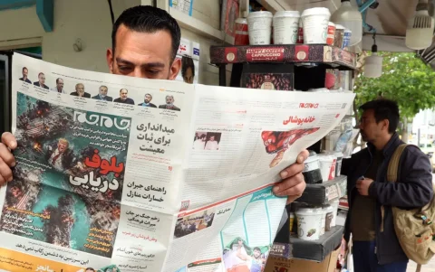 Un iraní lee el diario iraní Jame Jam con el titular 