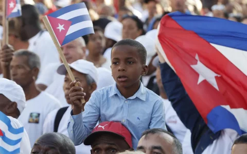Un niño sostiene la bandera de Cuba en la conmemoración del aniversario 65 de la proclamación del carácter socialista de la revolución, en La Habana (Cuba).