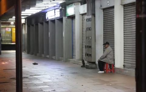 Un guardia vigila una calle desolada en la noche.