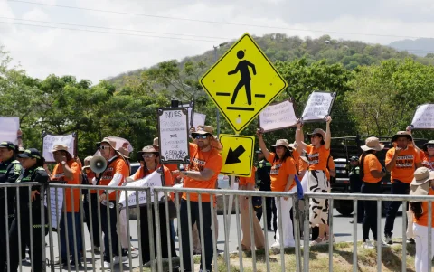 Personas sostienen carteles en una manifestación durante la conferencia en Santa Marta (Colombia).