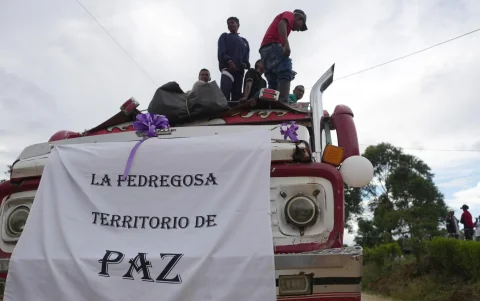 Personas participan en una caravana que transporta cuerpos de víctimas mortales de la explosión de un cilindro bomba, en Cajibío (Colombia).