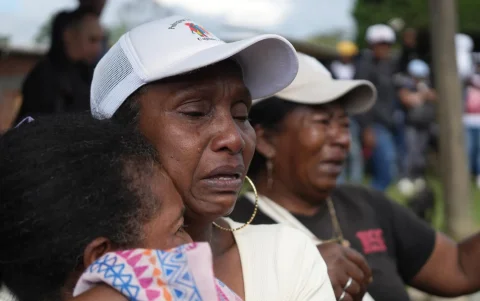Mujeres lloran durante una caravana que transporta cuerpos de víctimas, en el Corregimiento de La Pedregosa de Cajibío (Colombia).