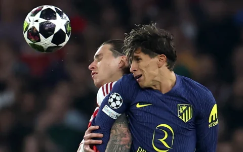 Riccardo Calafiori de Arsenal y Giuliano Simeone de Atlético de Madrid luchando la pelota.