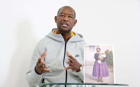 Beber Espinoza junto a una foto del recuerdo de su madre cuando lo tenía a él en brazos.