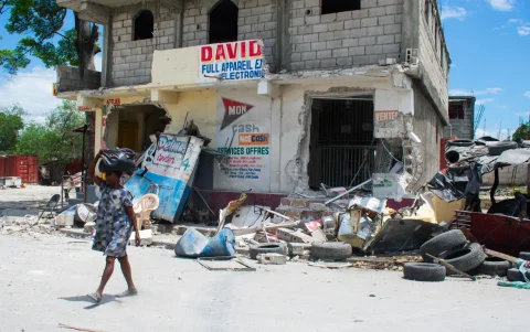 Una mujer camina con pocas pertenencias tras enfrentamientos entre grupos armados, este martes 12 de mayo de 2026, en Puerto Príncipe (Haití).