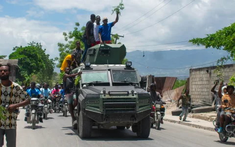 Personas celebran la llegada de la Policía Nacional Haitiana (PNH) a una zona del barrio Cité Soleil tras enfrentamientos entre grupos armados, en Puerto Príncipe (Haití).