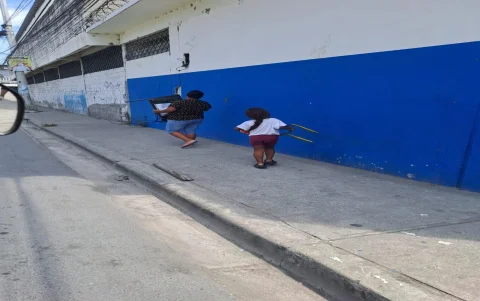 Padres y estudiantes retiran pupitres de la escuela para repararlos antes del inicio de clases.