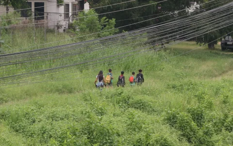 Jóvenes caminan hacia su escuela en la vía a la costa.