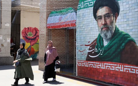 Ciudadanas iraníes pasan junto a una fotografía del líder supremo iraní, el ayatolá Mojtaba Khamenei, en una calle de Teherán, Irán, el 18 de mayo de 2026.