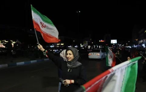 Una mujer sostiene la bandera nacional de Irán durante una concentración en apoyo del gobierno iraní contra Estados Unidos e Israel, en Irán, el 20 de mayo de 2026.