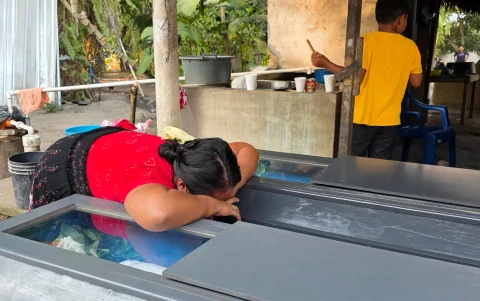 Una mujer llora sobre los féretros de los hermanos Elmer y Wilmer Suchite durante su velorio este viernes, en Rigores (Honduras).