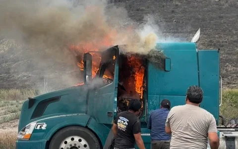 Un grupo de personas intenta apagar un camión que se quema durante un bloqueo en Villa de Mitla (México).