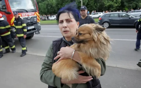 Una mujer rumana con su perro en brazos se encuentra cerca del lugar donde un dron ruso se estrelló contra un edificio residencial.