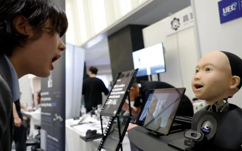 Una joven interactúa con un robot humanoide en el stand de Avita durante la Cumbre de Humanoides en Tokio, Japón, el 28 de mayo de 2026.