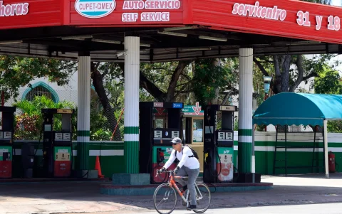 Una persona pasando en bicicleta frente a una estación de gasolina cerrada en La Habana (Cuba).