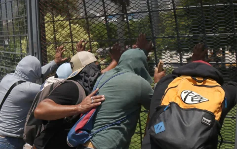 Integrantes de la Coordinadora Nacional de Trabajadores de la Educación (CNTE) intentan derribar una valla durante una protesta.
