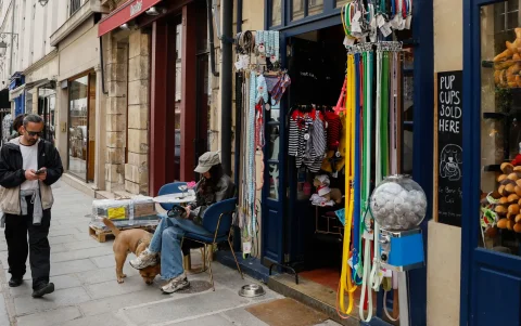 Naomi Bardiaux posa con su perro Ben, una mezcla de chow chow y bulldog, frente a la cafetería para perros