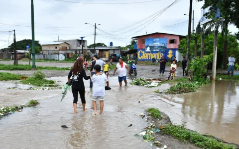 Vecinos atraviesan calles anegadas en Machala mientras autoridades suspenden clases y evalúan daños por las persistentes lluvias.