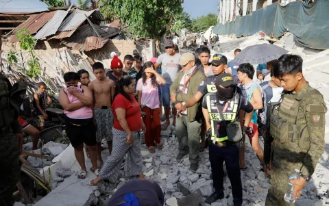 Civiles, personal de seguridad privada y soldados del ejército filipino se encuentran entre los escombros un día después del terremoto, al sur de Filipinas, el 9 de junio de 2026.