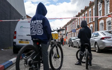 Varias personas inspeccionan los daños en la calle Lendrick, tras los disturbios ocurridos en Belfast, Irlanda del Norte, el 10 de junio de 2026.