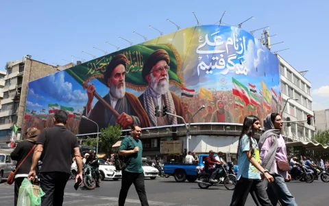 Ciudadanos iraníes pasan junto a una gran valla publicitaria con la imagen del difunto líder supremo iraní, en una calle de Teherán, Irán, este 10 de junio de 2026.