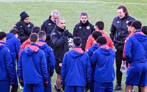 Sabri Lamouchi imparte indicaciones al plantel de Túnez en el centro del campo durante una sesión de entrenamiento.