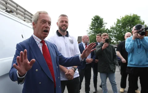 El líder de Reform UK, Nigel Farage (izquierda), habla a las afueras de un colegio electoral en Wigan, Gran Bretaña, el 18 de junio de 2026.