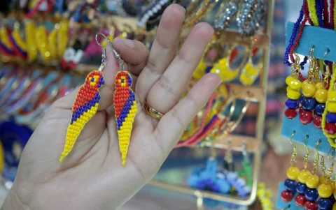 Aretes con forma de papagayo en los colores del Ecuador, en el Mercado Artesanal.
