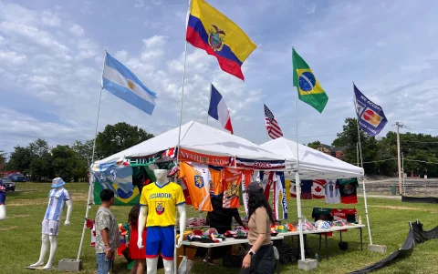 Entre camisetas y recuerdos mundialistas, las banderas de Ecuador destacan en los puestos instalados cerca de las zonas de aficionados en Kansas City.