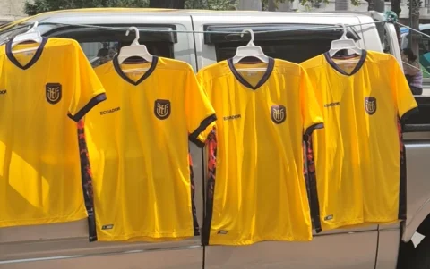 Vendedores exhiben camisetas de la selección en Guayaquil, en medio del auge comercial previo al partido del Mundial.