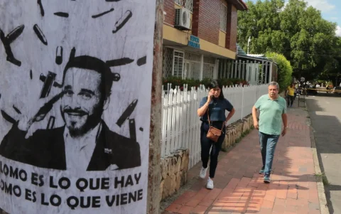 Personas caminan junto a un cartel alusivo al ultraderechista Abelardo de la Espriella.