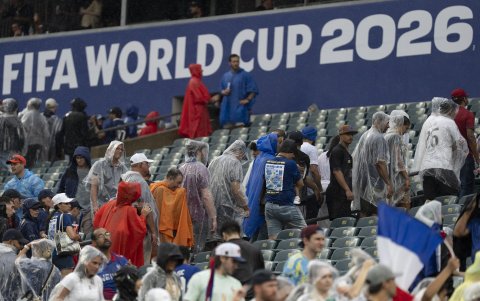 Aficionados se cubren de la lluvia.