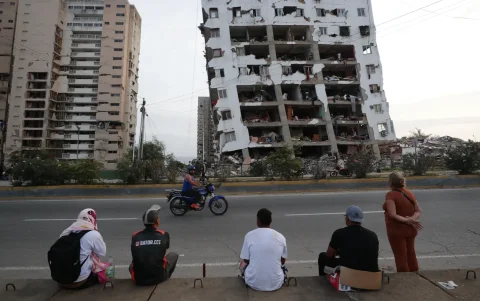 Residentes observan uno de los bloques de viviendas dañados por los terremotos en La Guaira.