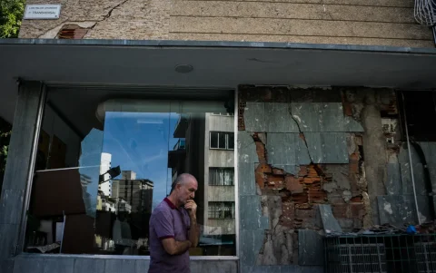 Una persona camina frente a edificios colapsados por los terremotos este jueves, en el municipio de Chacao, en Caracas (Venezuela).