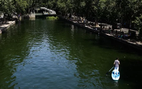 Un hombre navega por el Canal Saint-Martin, en París, Francia.