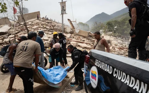 Voluntarios trasladan un cuerpo rescatado entre los escombros tras los terremotos en La Guaira, Venezuela