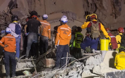 Integrantes de Protección Civil y voluntarios trabajan entre los escombros tras el terremoto en Venezuela.