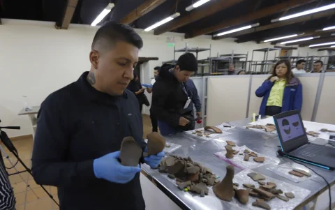 Una pieza de cerámica recuperada durante las excavaciones es examinada.