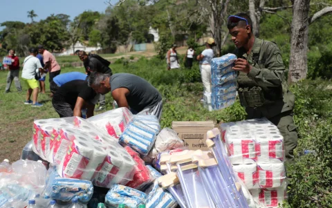 Personas descargan ayudas humanitarias este lunes en La Guaira, Venezuela, tras los sismos.