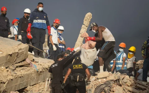 Equipos de rescate trabajan entre los escombros en La Guaira, mientras persisten denuncias de saqueos tras el terremoto.